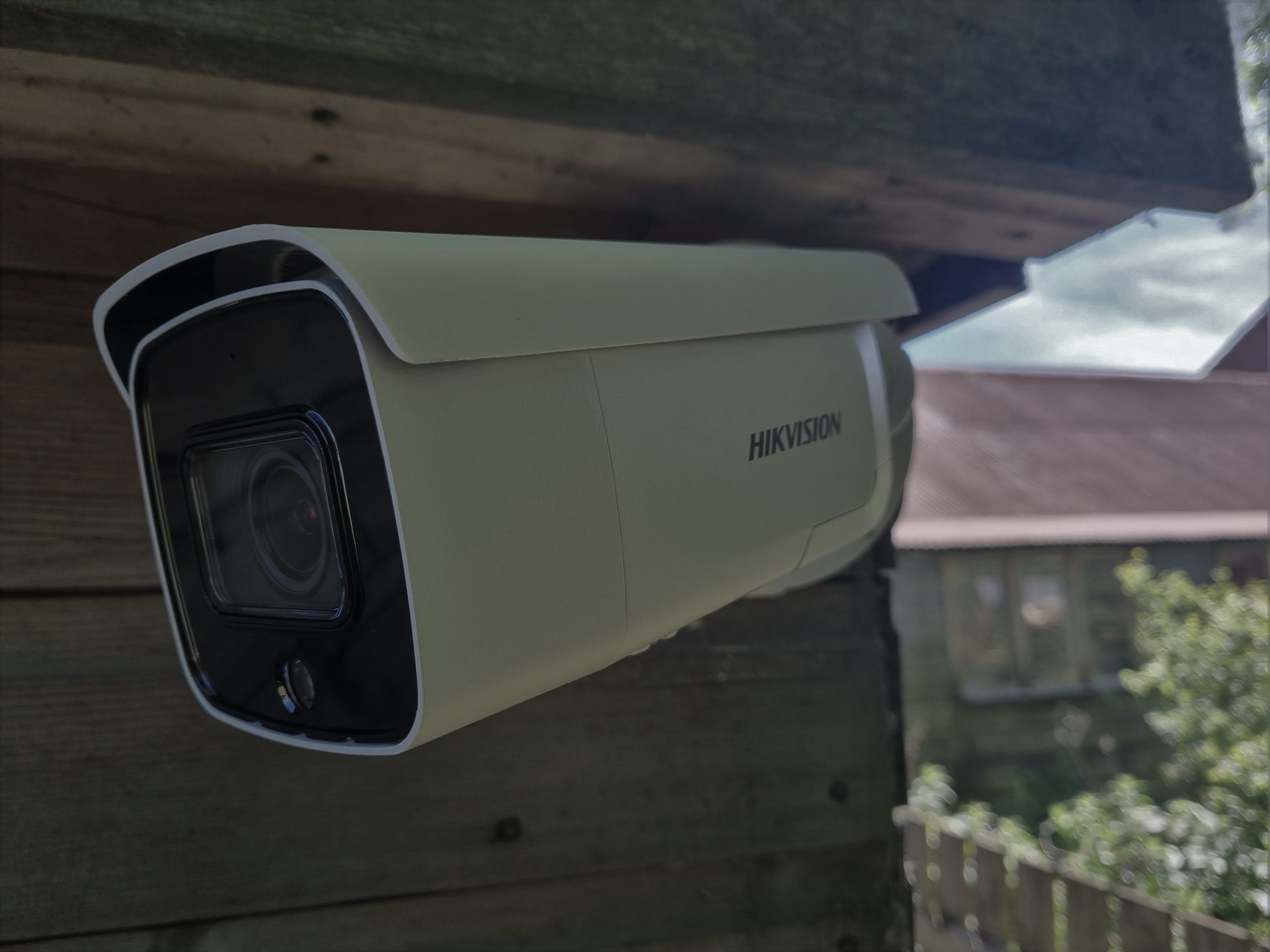A white CCTV camera on a wooden building