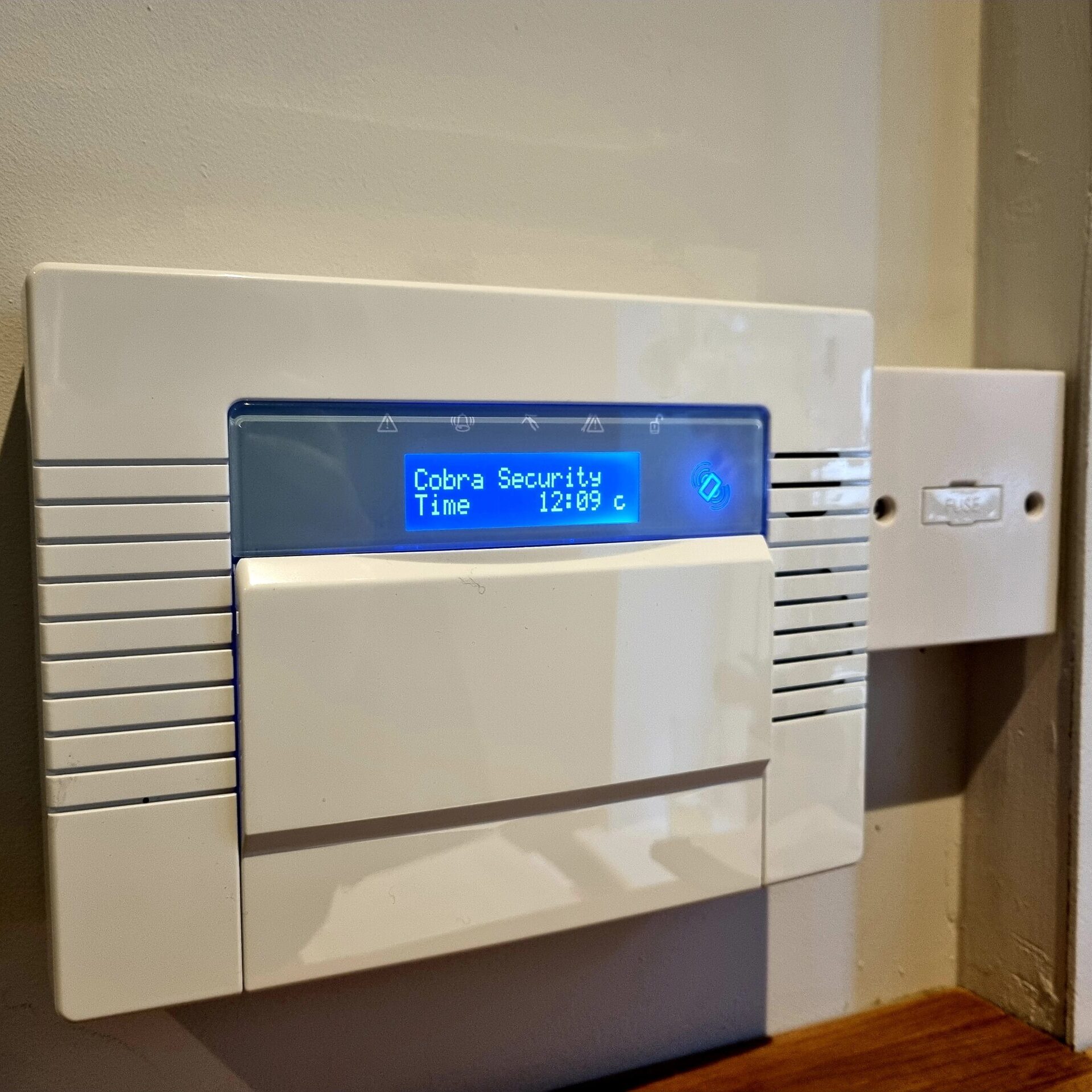 a wireless intruder alarm control panel with a blue display