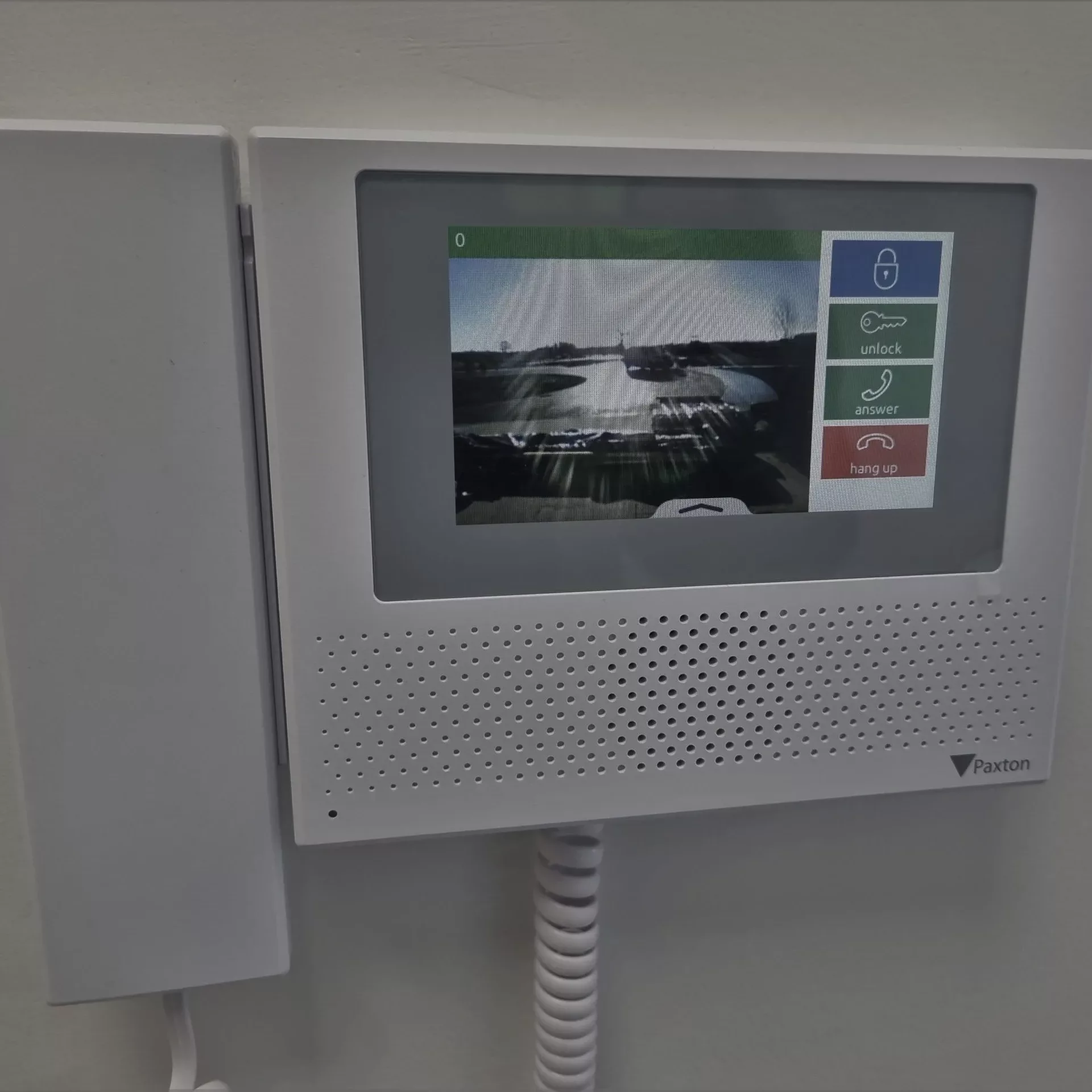 Intercom system handset showing a display of outside on the screen