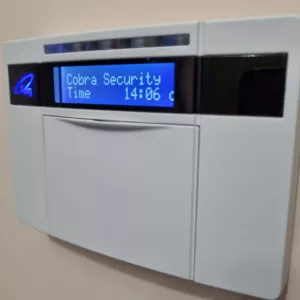 a white intruder alarm keypad with a blue display