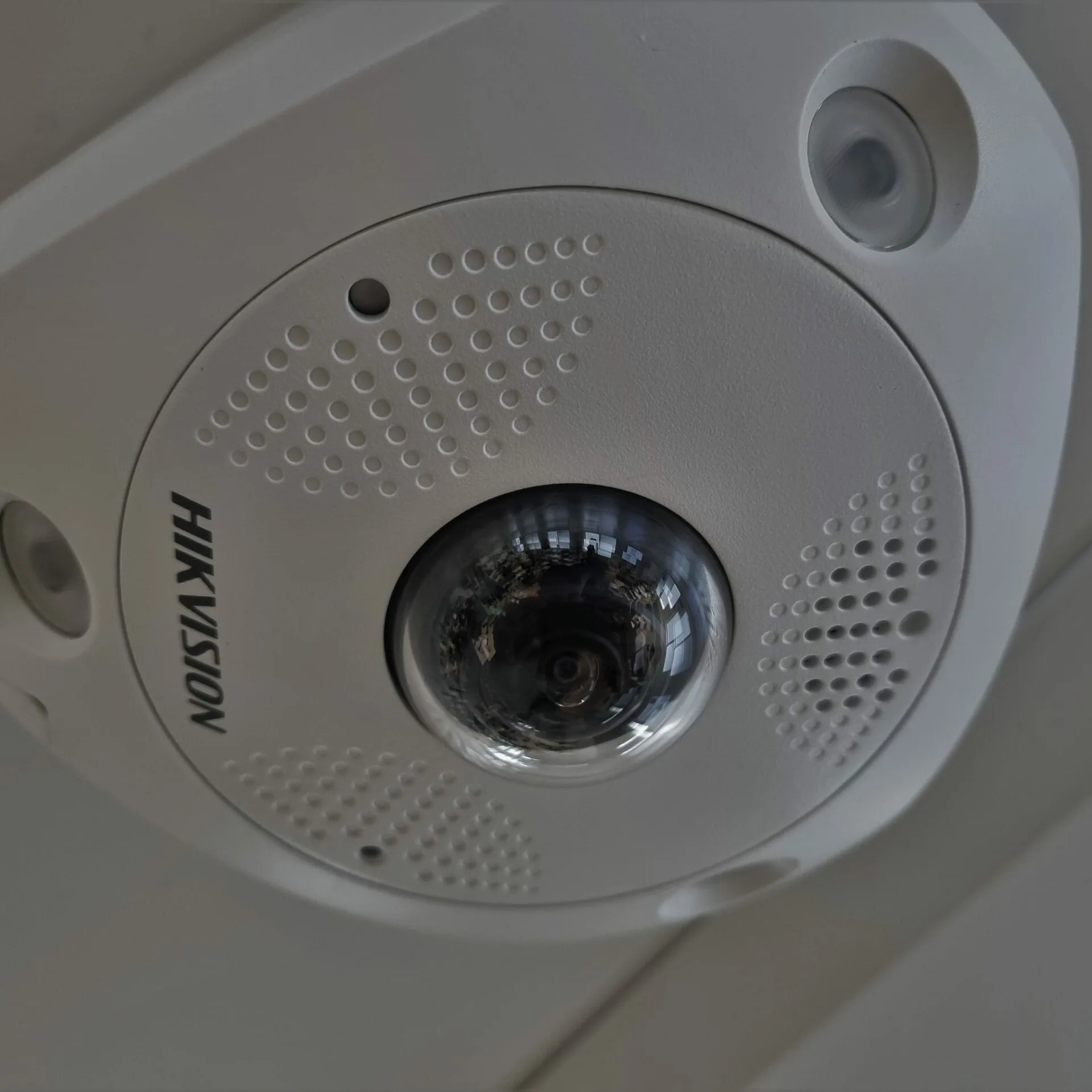 Hikvision CCTV camera mounted on a ceiling, part of a security system with audio recording.