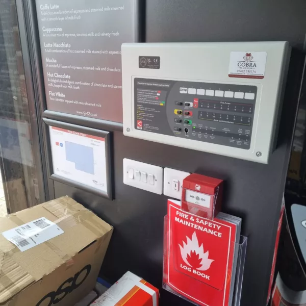 Image of a Fire Alarm control panel. Also on display is a manual call point, log book and building diagram